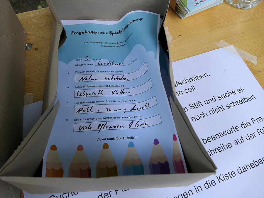 ausgefüllter, kindgerecht gestalteter Fragebogen in einer Kiste