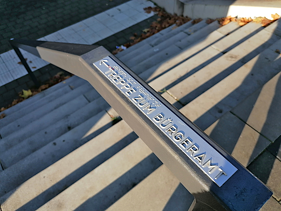 Geländer mit Aufschrift an Außentreppe mit Aufschrift Bürgeramt und Braille-Schrift