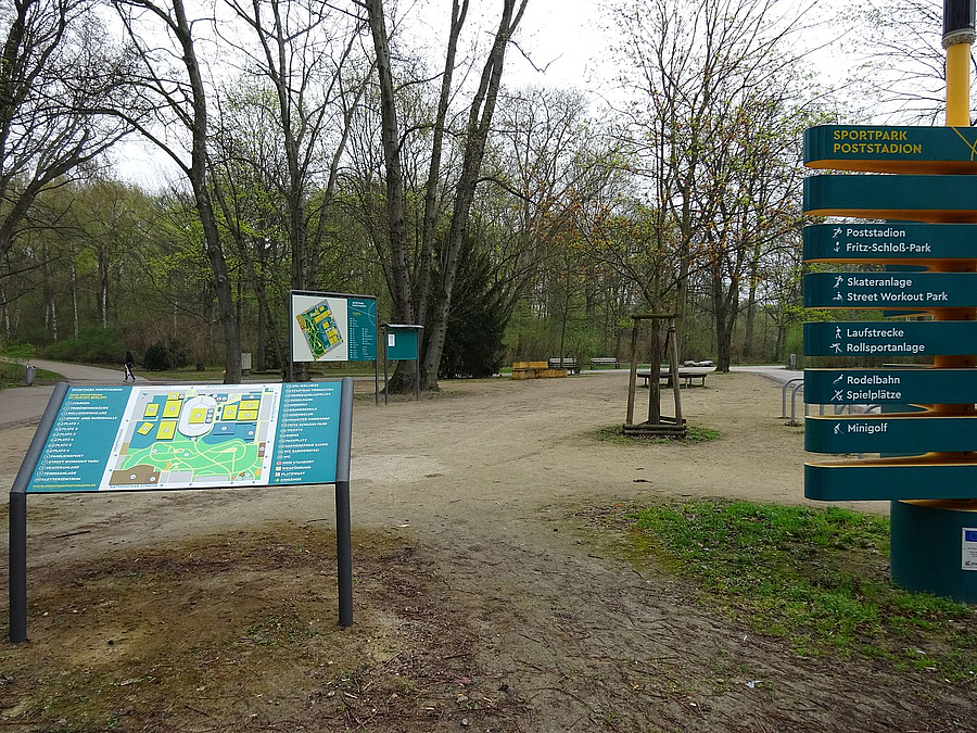 Wegegabelung im Park im Frühling; Stele, horizontale und schräge Infotafel