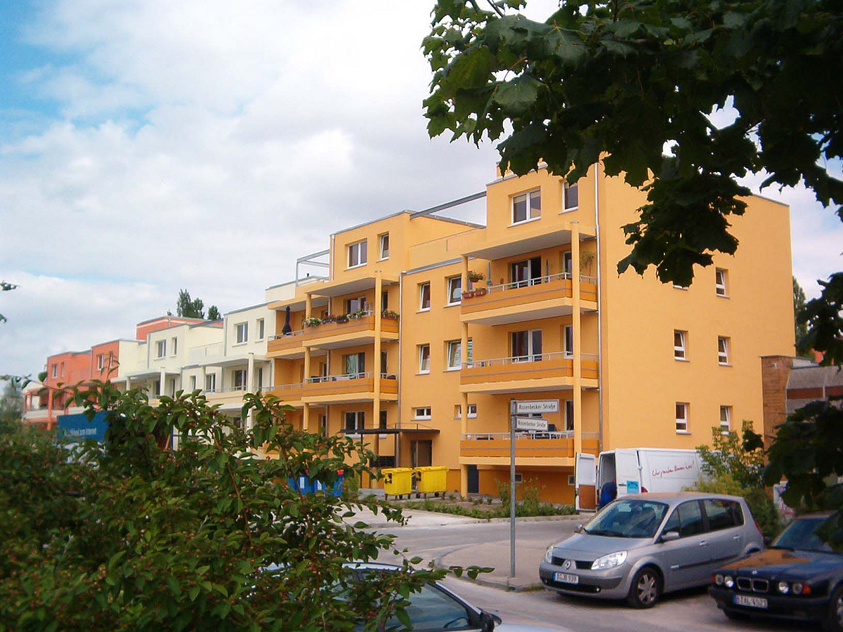 Dreigeschosser in verschiedenen Farben mit Balkonen und Dachterrassen, Grün, Parkplätze