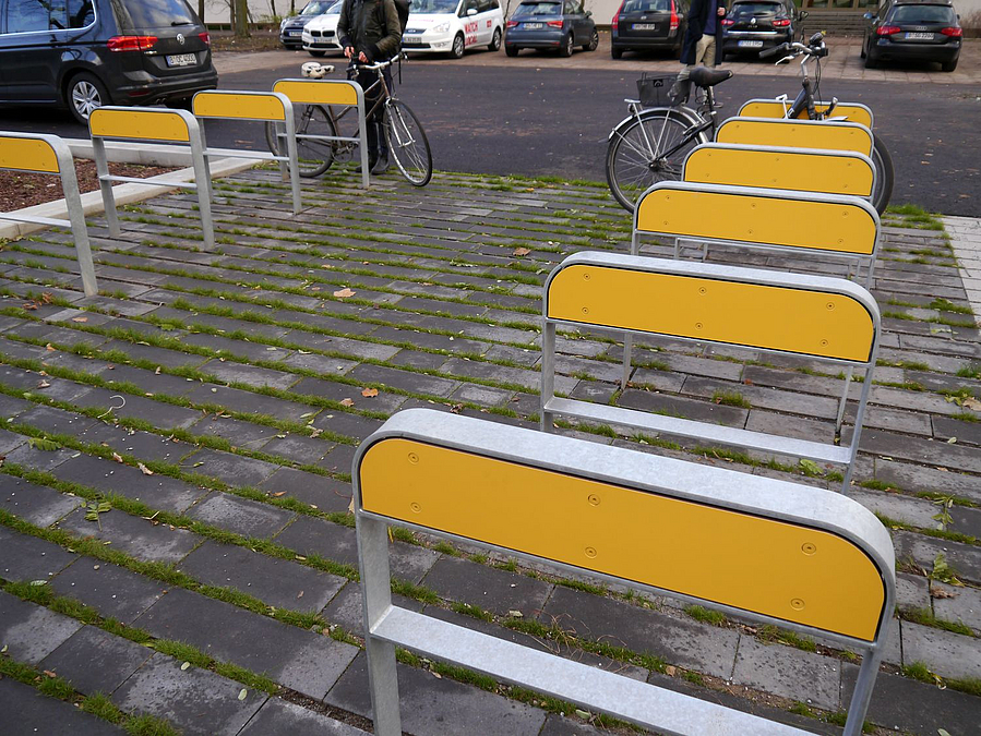 Fahrradbügel mit gelber Platte im oberen Bereich