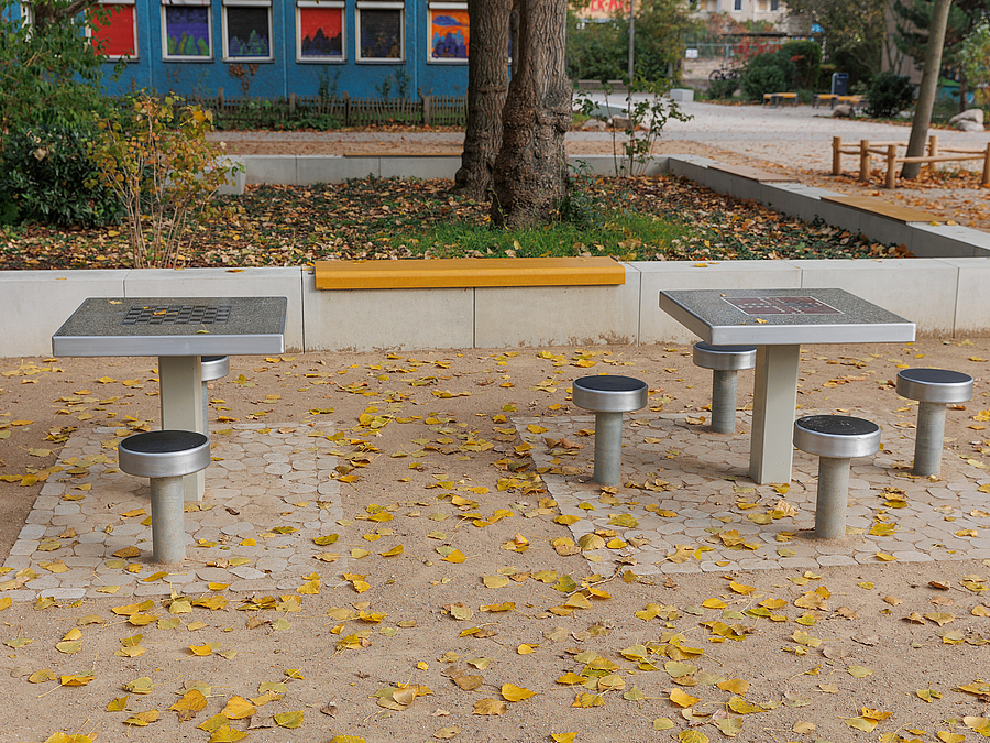 Schachtische auf wassergebundener Wegedecke, Sitzkante mit Auflage um Baum