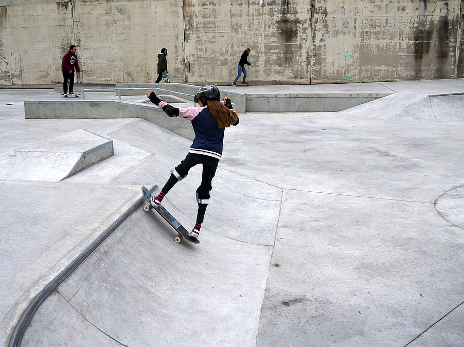 Mädchen fährt mit Skateboard schräge Kante