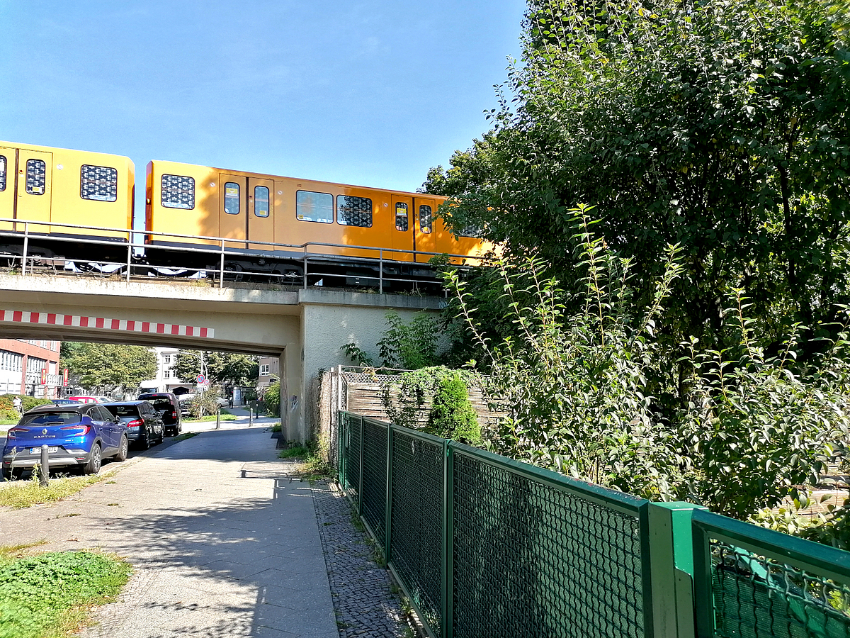 Straße unter U-Bahn-Damm, Garten, parkende PKW