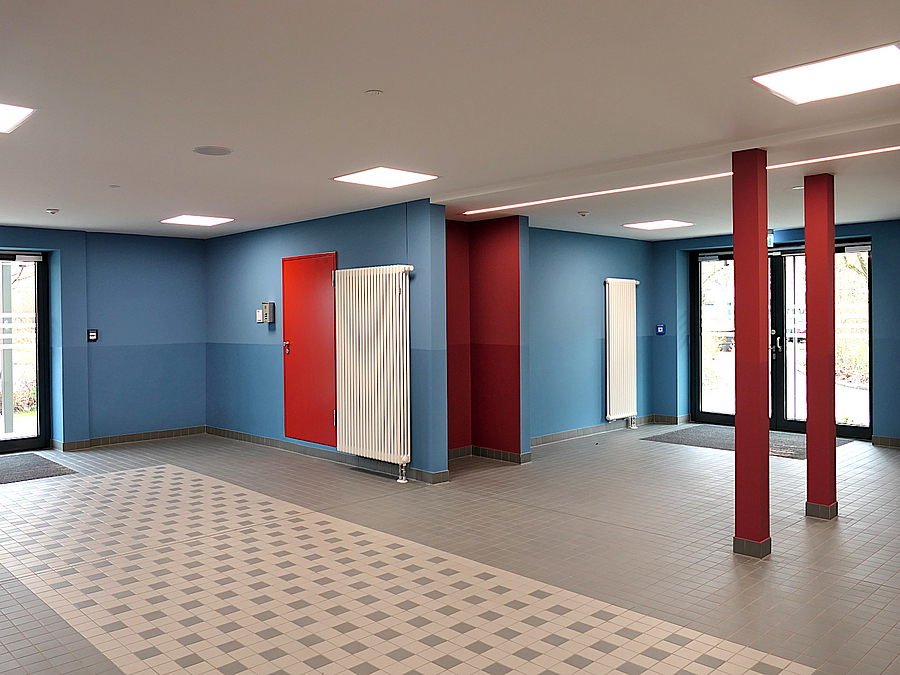 Foyer mit blauen Wänden und roten Akzenten, Stützen, Eingängen