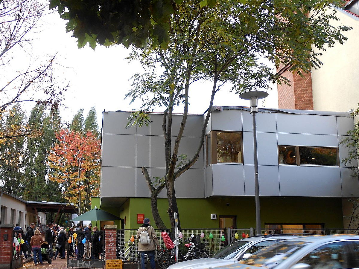 Modernes grau-grünes Gebäude mit Plattenverkleidung an der Straße