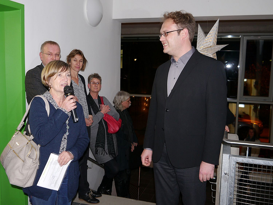 Menschen auf Treppe, Christine Keil spricht, neben ihr André Henselmann