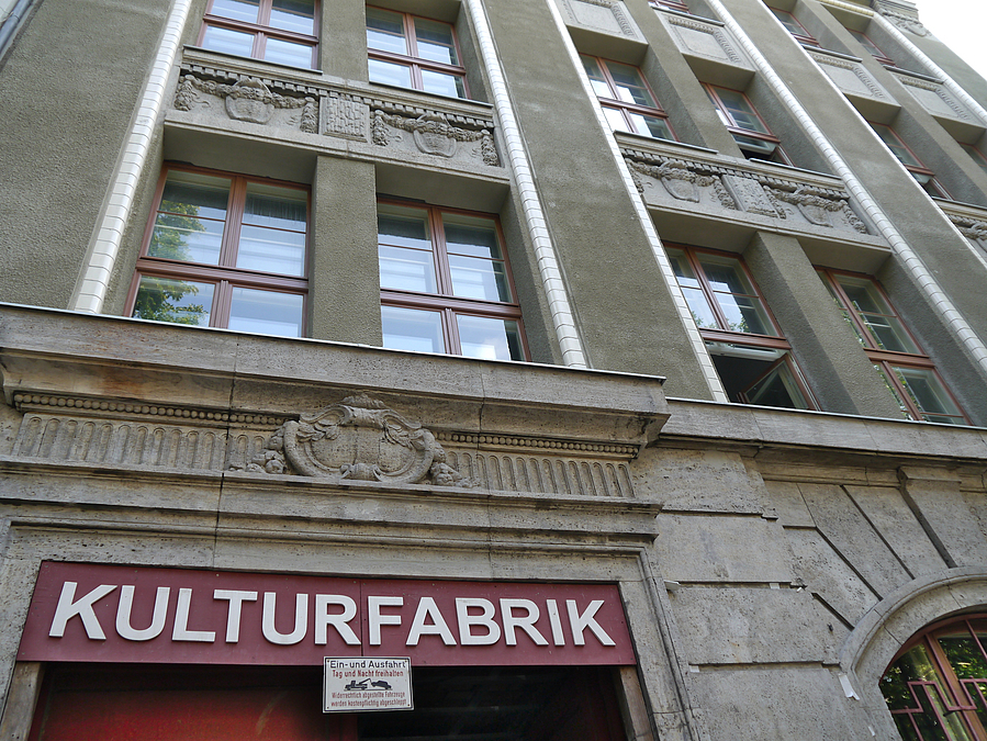 Blick an alte Fassade nach oben, Schild "Kulturfabrik" über Tor