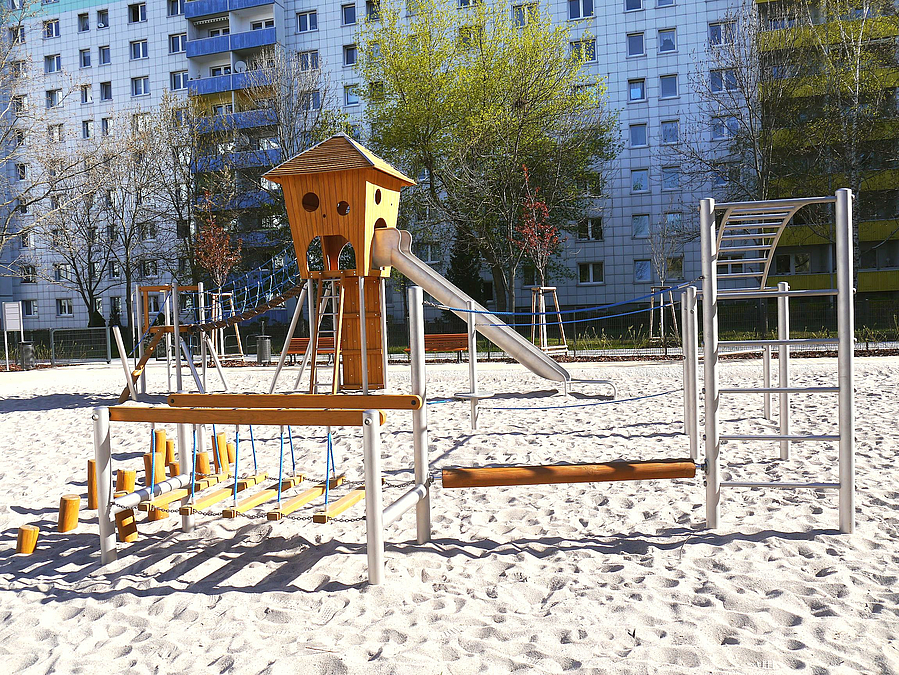 Sandfläche mit Rutschenturm und Balancierparcours aus Stahl und Holz