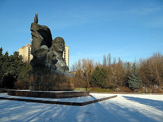 Monumentales Denkmal auf winterlichem Platz, dahinter Bäume