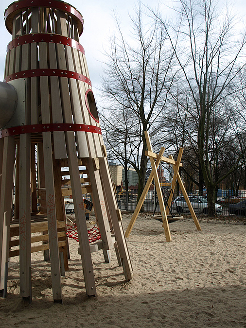 Spielturm und Rutsche aus Holz auf Sand