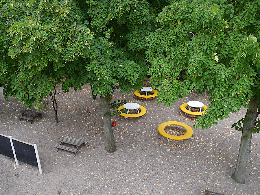 Vogelperspektive auf gelbe runde Sitzkombinationen unter Laubbäumen, Maltafel
