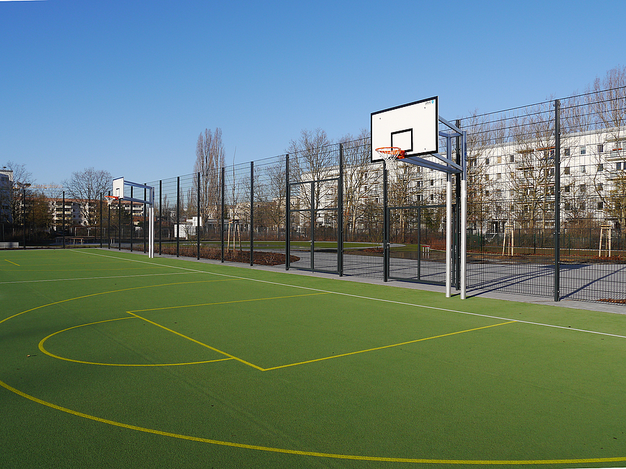 Grünes Sportfeld mit Linierung und 2 Basketballständern