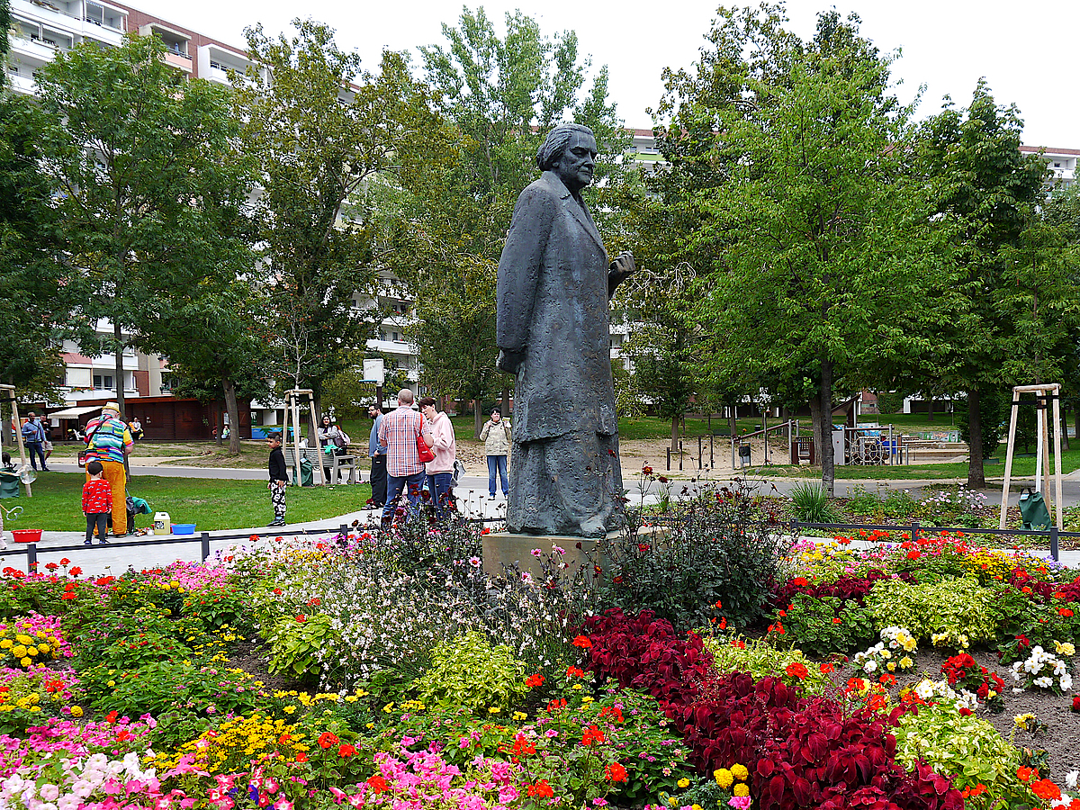 Denkmal Clara Zetkin im Blumenbeet, Laubbäume