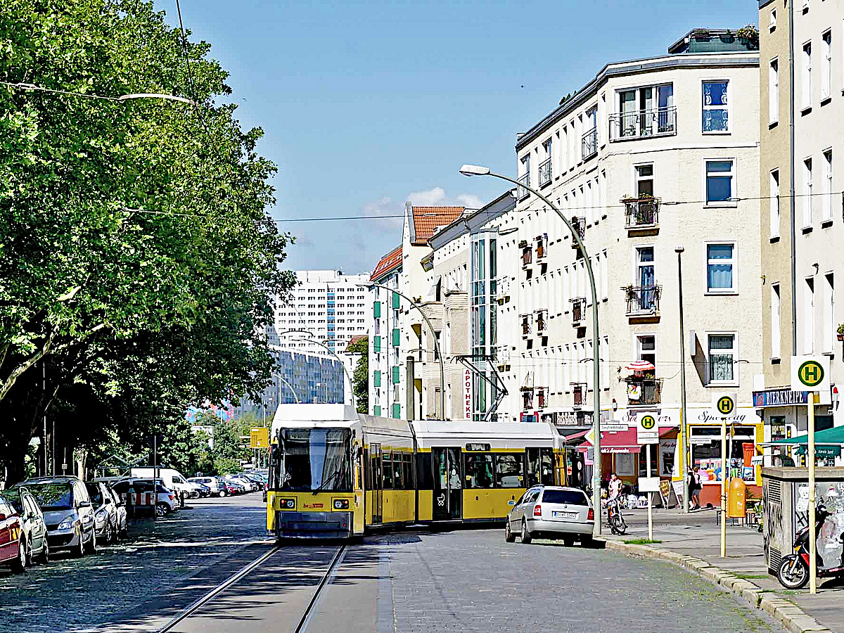 Geschäftsstraße mit Straßenbahn und Bäumen