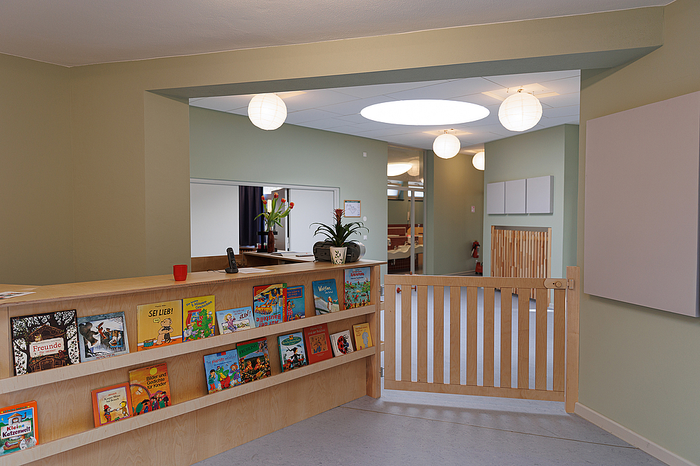 Raum mit Büchertresen und kleiner Holzstrennwand