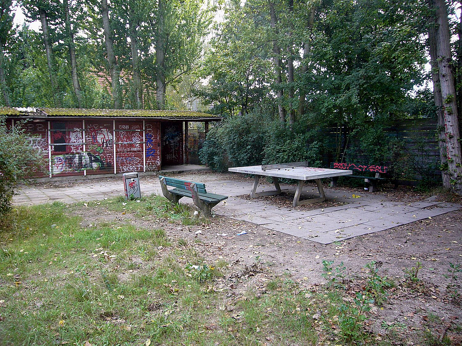 Abgenutzter Rasen, Tischtennisplatte, Kleines Blockhaus