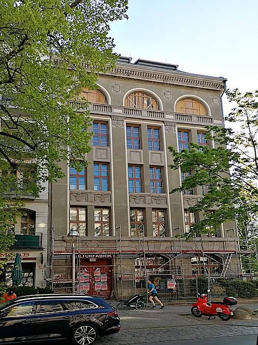 Historisches Gebäude mit großen Fenstern, Straßenszene