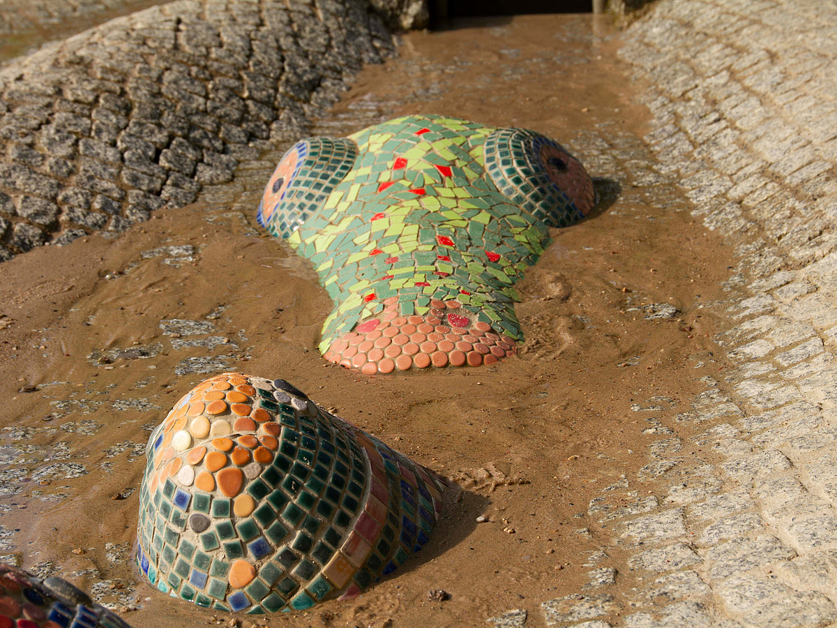 Buntes Mosail Amphibienkopf in gepflasterter Rinne