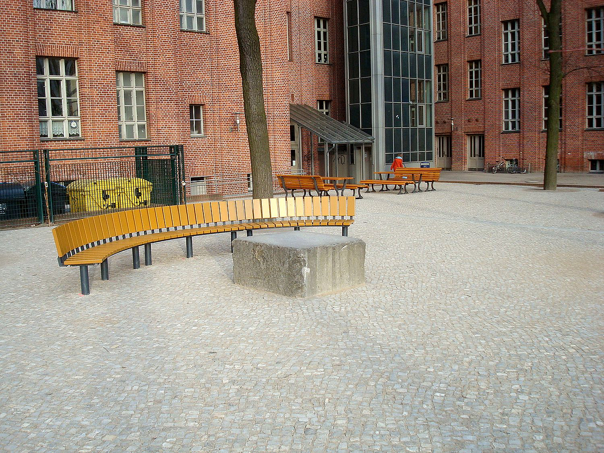 Pflasterfläche, im Hintergrund Backsteingebäude