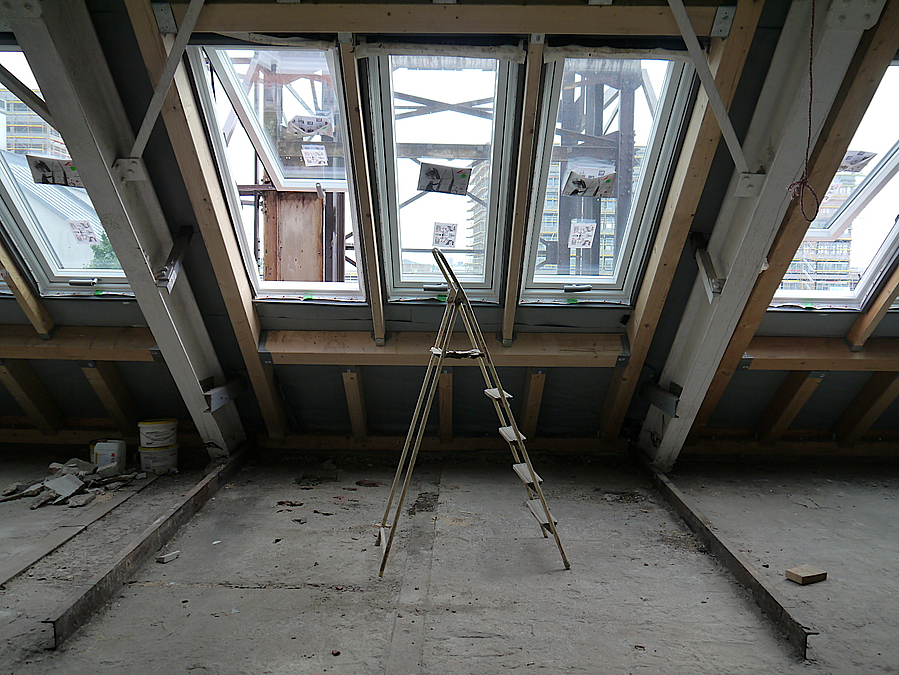 Schräges, dreigeteiltes Dachfenster von innen, davor Stehleiter