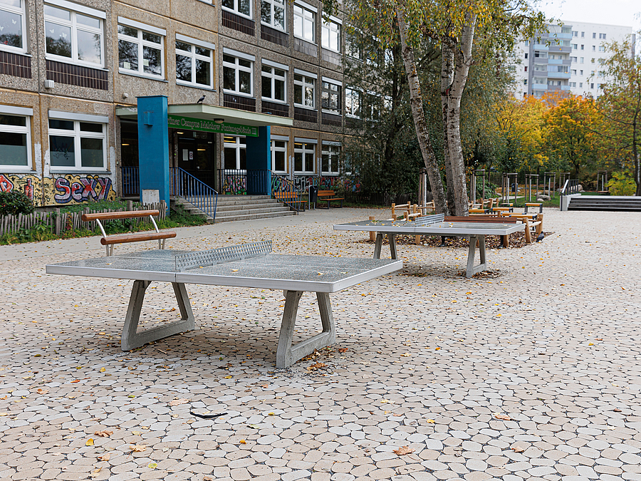 Tischtennisplatten vor älterem Typen-Schulgebäude