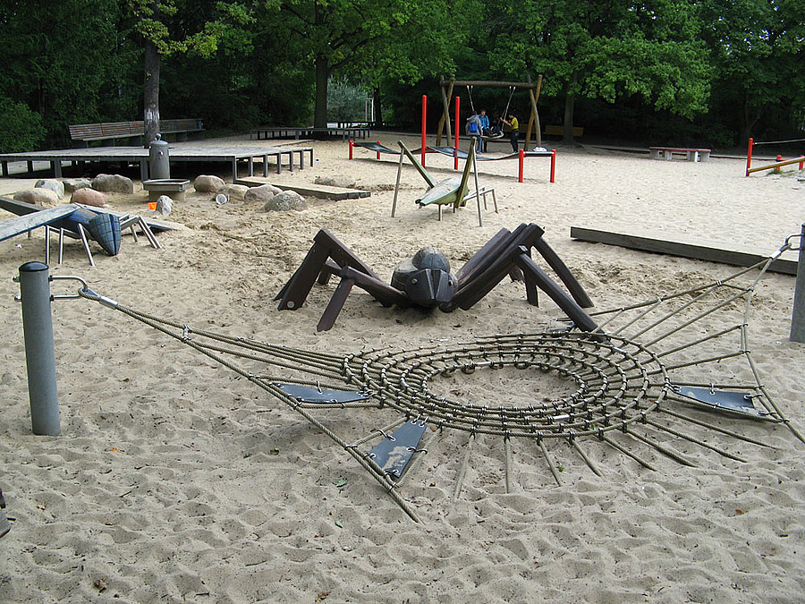 Netz und große Holzspinne auf Sandspielplatz