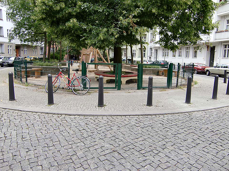 Runder Platz in Wohnstraße, durch Poller gesicherter Gehweg, Spielplatz