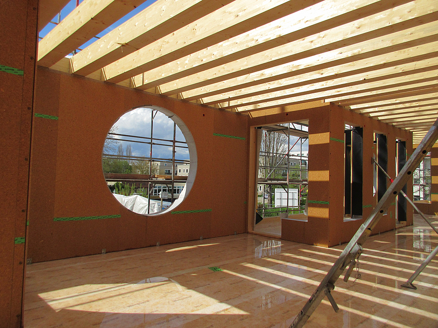 Raum aus Holz im Bau mit großem runden Fenster