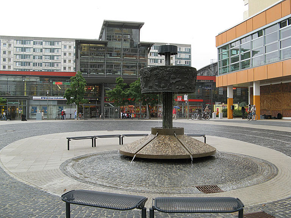 Brunnen auf gepflastertem Platz vor Einkaufszentrum