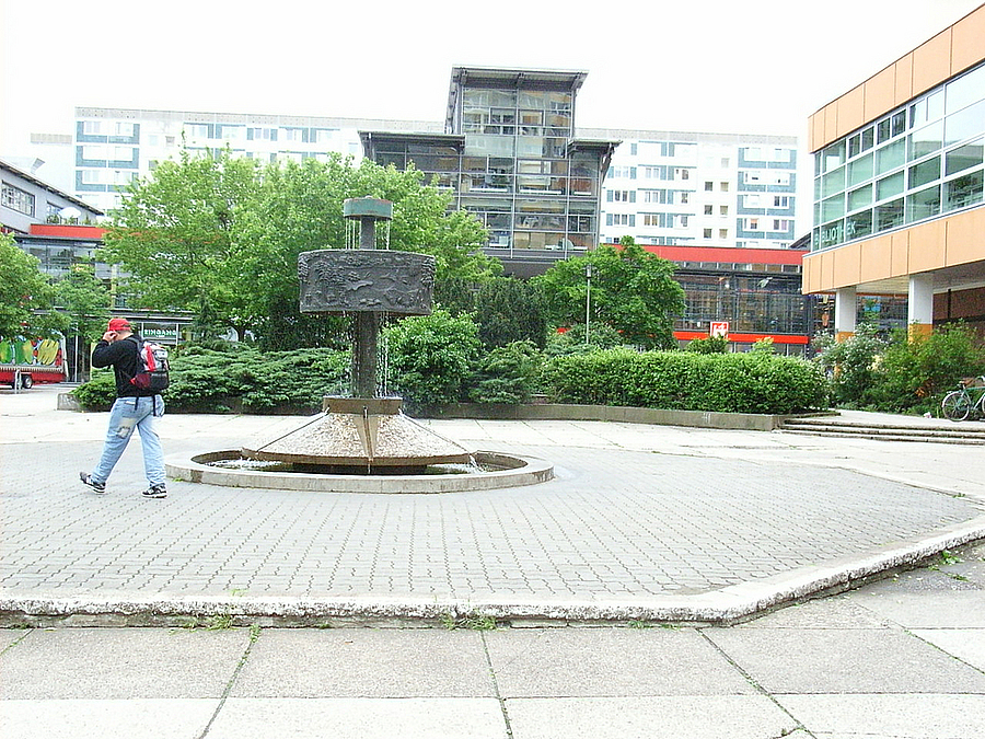 Brunnen auf Platz mit rauer Kante, Grün, moderne GEschäftsbauten