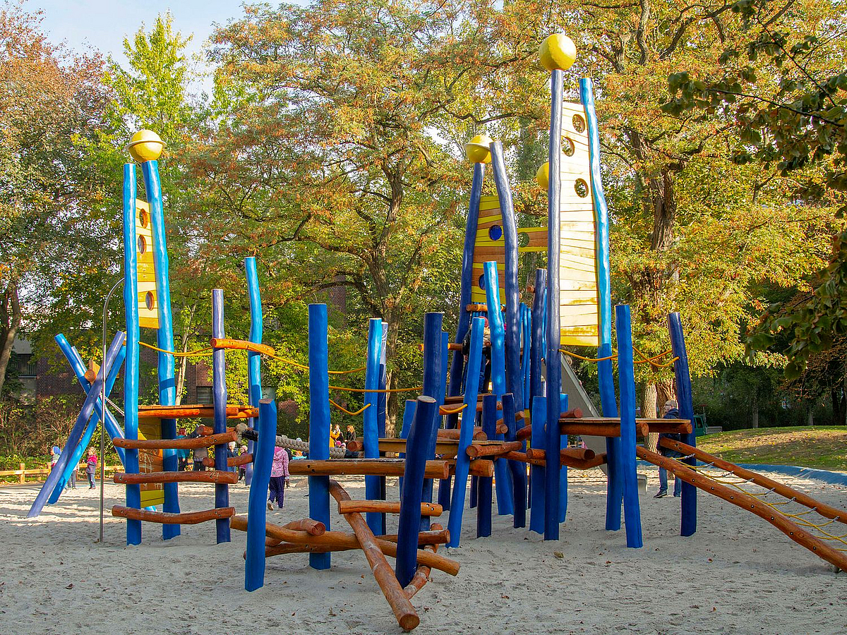 Kletterspielgerät aus Holz mit Spitzen und Kugeln im Herbst