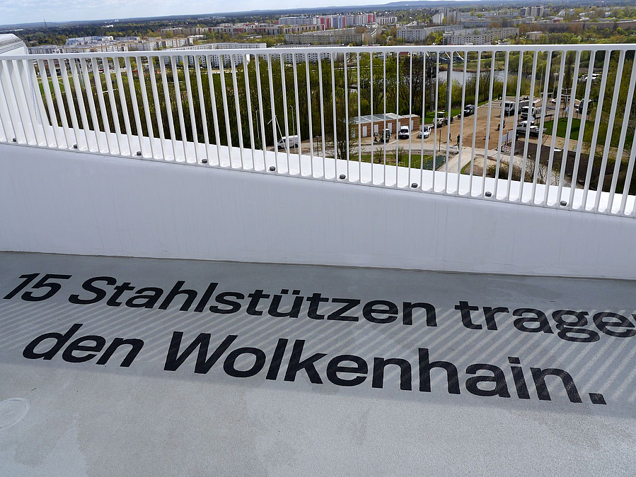 Geländer, darunter Schrift "15 Stahlstützen tragen den Wolkenhain"