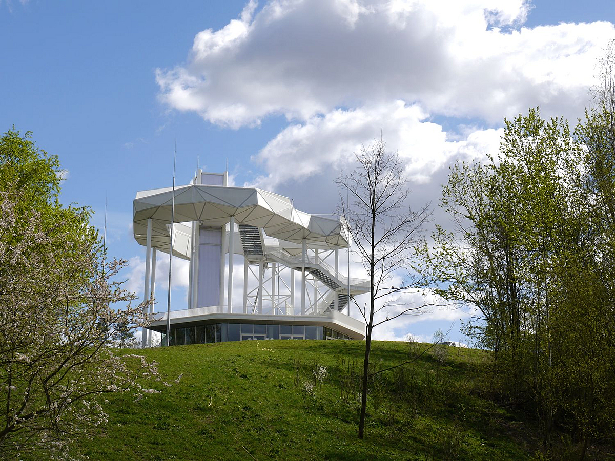 Filigranes weißes polygonales Bauwerk auf grünem Hügel