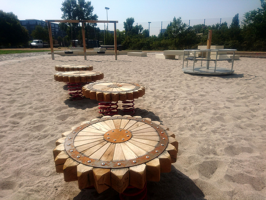 4 Sonnenförmige Holzscheiben auf Federn auf Sand