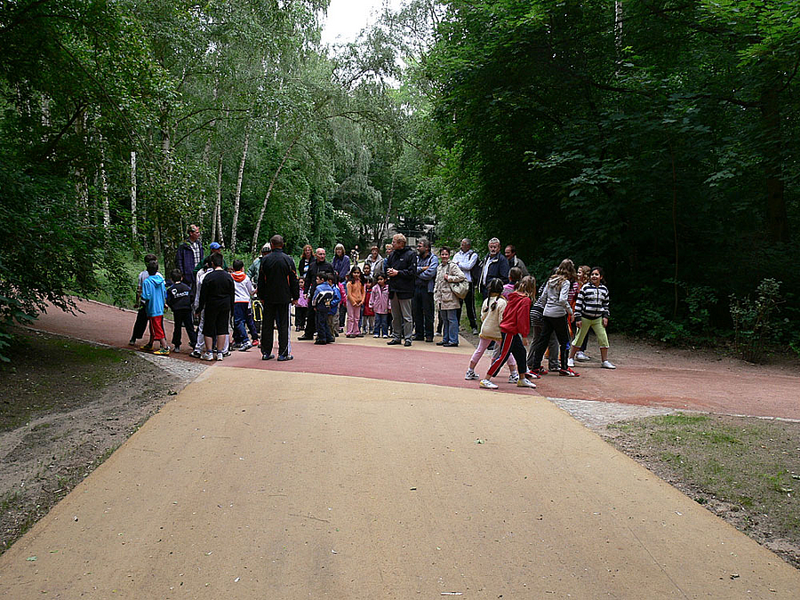 Gruppe mit Kindern seht an Wegkreuzung im Park
