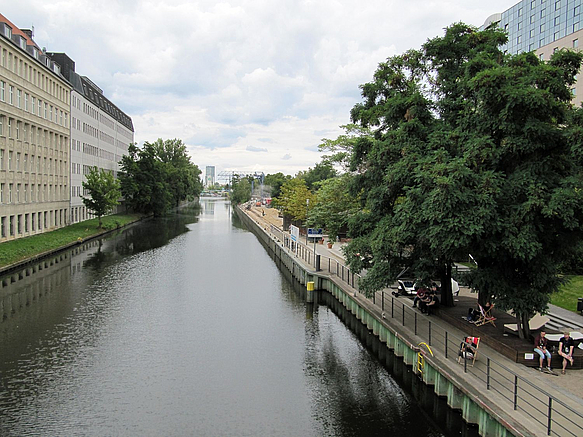 Blick auf Kanal mit Uferpromenade am rechten Ufer, im Hintergrund Baustelle