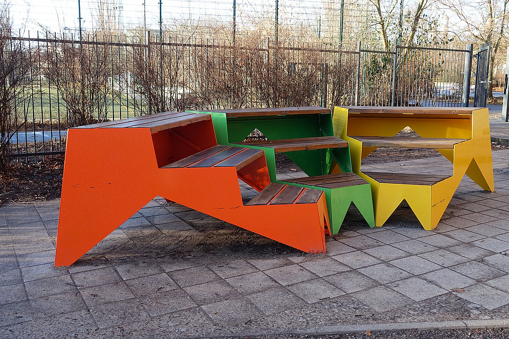Dreiteilige, dreistufiges Sitzpodest als Kreissegment in orange, grün und gelb